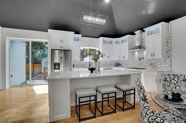 a kitchen with cabinets and chairs