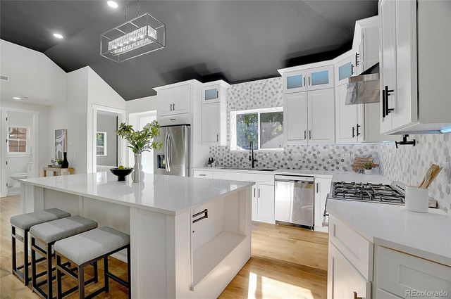 a kitchen with stainless steel appliances kitchen island granite countertop a stove and cabinets