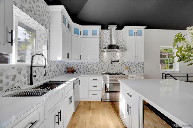 a kitchen with white cabinets a sink and a stove