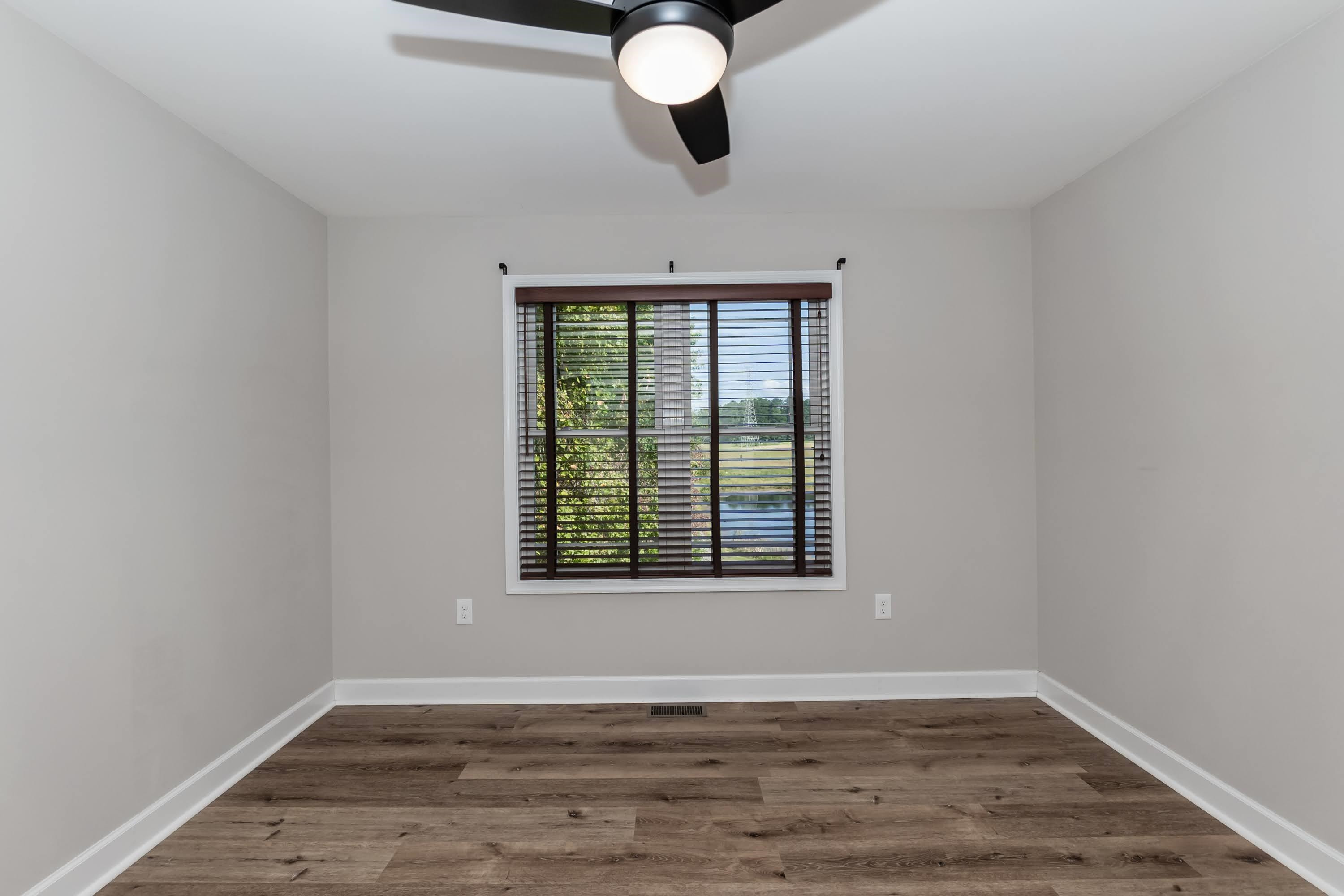 345 Fieldstone Road Roxboro, NC 27574 - Photo 17 of 34 a view of an empty room with wooden floor and a window