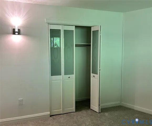 an empty room with closet and a bathroom
