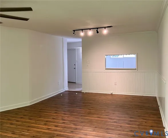 a view of an empty room with wooden floor