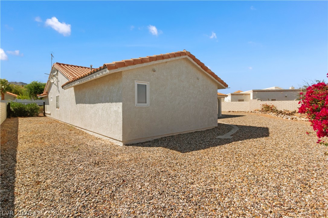 2055 Cholla Way Laughlin, NV 89029 - Photo 56 of 87 A terracotta tile roof accents this single-story structure, set on a gravel-covered lot.