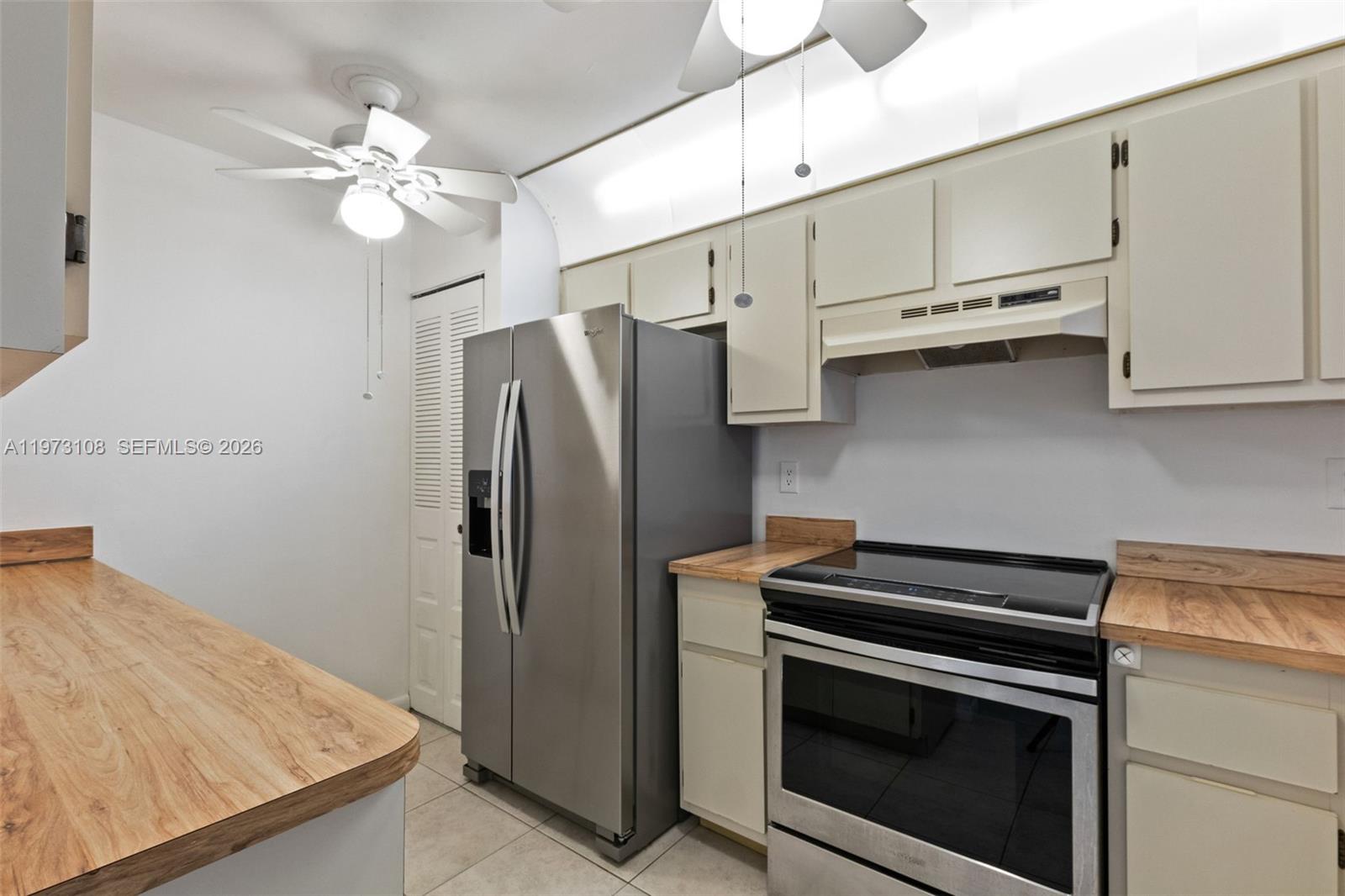 5356 Gate Lake Road, Unit 5356 Tamarac, FL 33319 - Photo 5 of 25 a kitchen with stainless steel appliances a stove microwave and cabinets