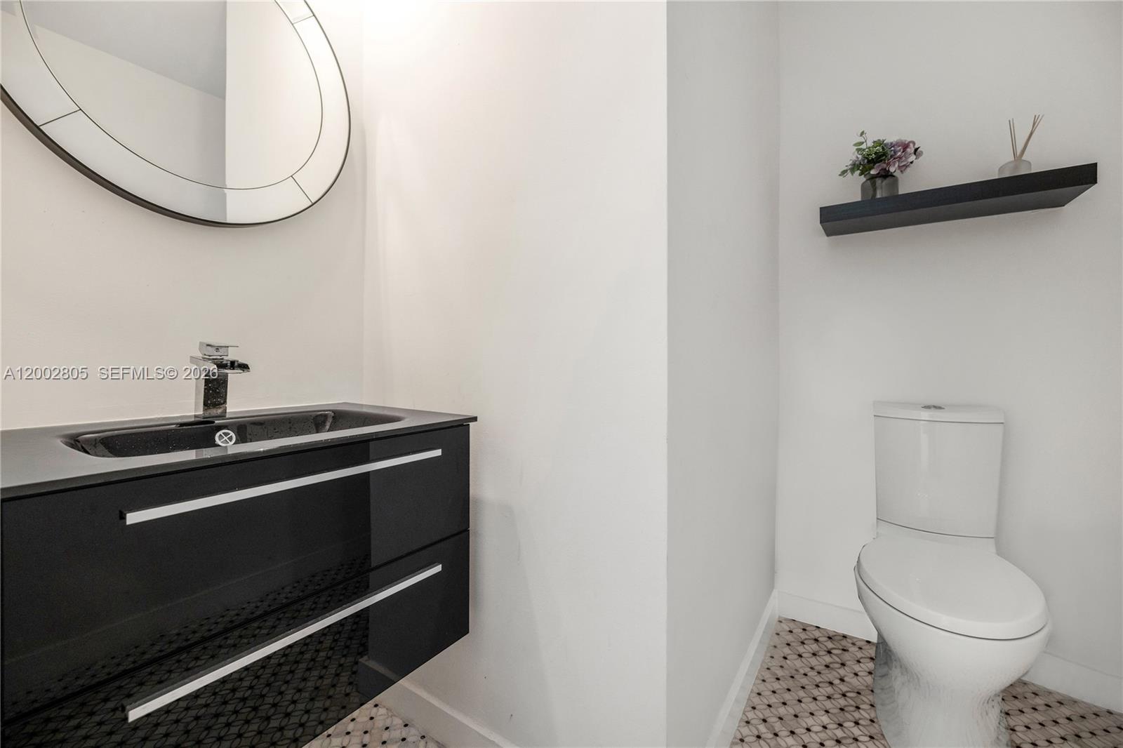 60 Southwest 13th Street, Unit 1124 Miami, FL 33130 - Photo 18 of 30 a bathroom with a toilet and a mirror