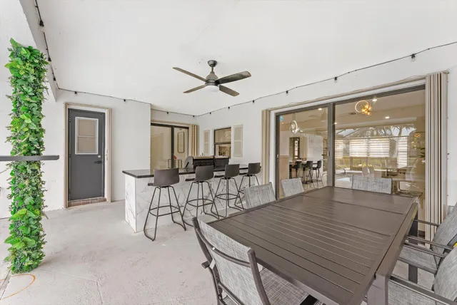 a dining room with furniture and a floor to ceiling window