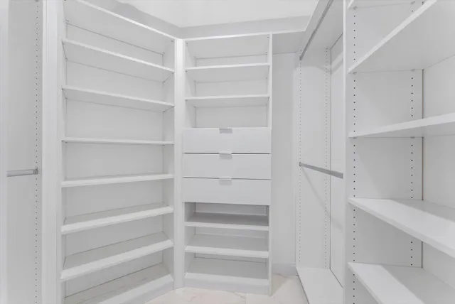 a spacious bedroom with a bed and a flat screen tv