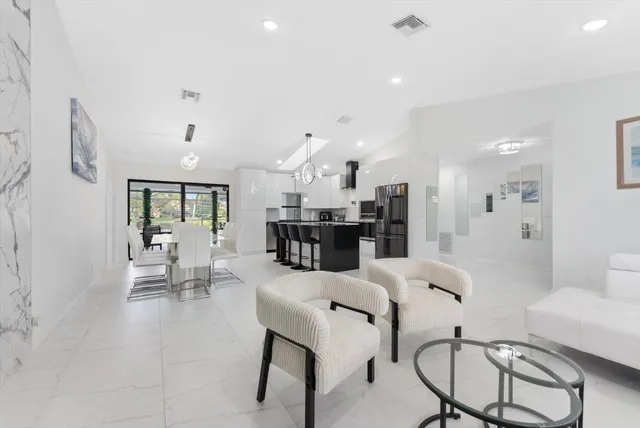 a living room with furniture and kitchen view