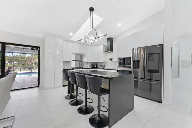 a kitchen with stainless steel appliances granite countertop a sink a stove and a refrigerator