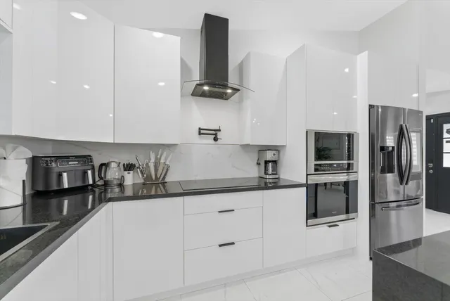 a kitchen with stainless steel appliances granite countertop a refrigerator and a sink
