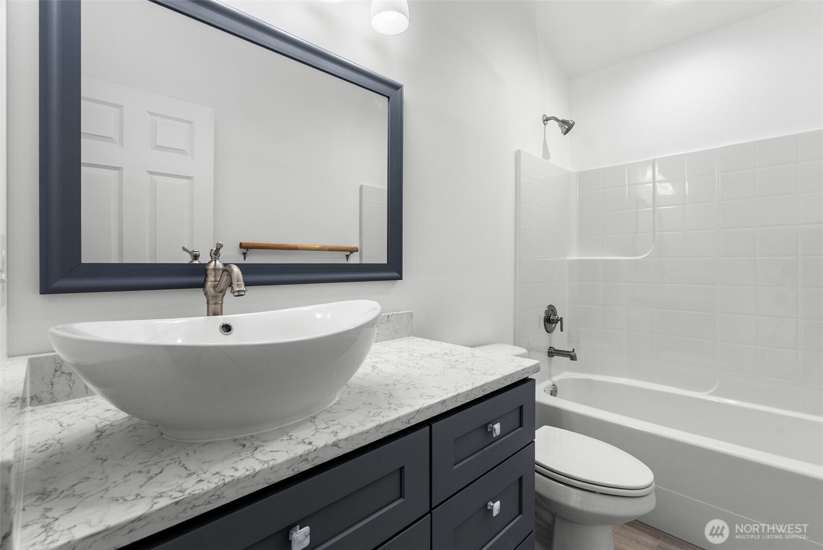 6925 Schweitzer Place Southwest Port Orchard, WA 98367 - Photo 24 of 32 a bathroom with a granite countertop sink a toilet a mirror and shower