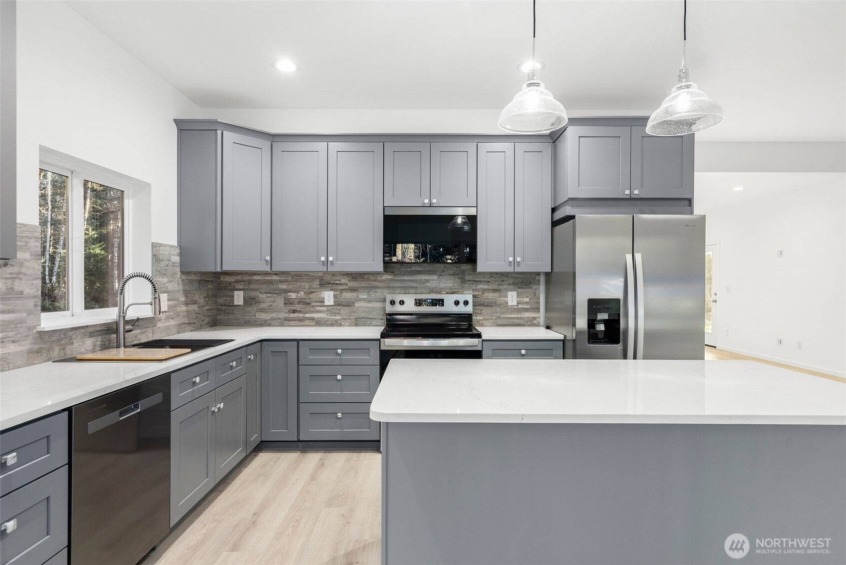 6925 Schweitzer Place Southwest Port Orchard, WA 98367 - Photo 9 of 32 a kitchen with a sink a stove a refrigerator a center island and a window