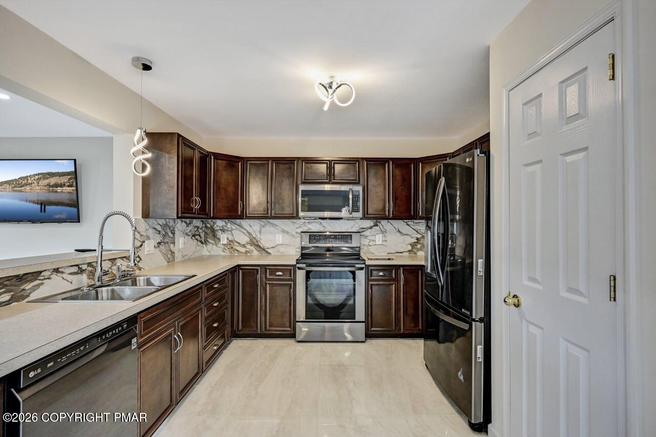 1013 Bear Swamp Road East Stroudsburg, PA 18302 - Photo 14 of 53 a kitchen with stainless steel appliances granite countertop a stove sink and refrigerator