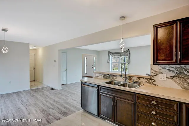 a kitchen with kitchen island granite countertop wooden cabinets and a sink