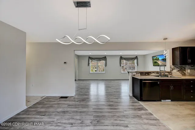 a kitchen with a sink dishwasher a stove and a refrigerator with wooden floor