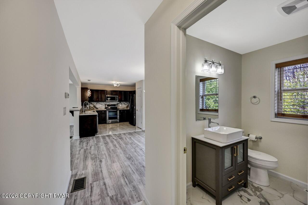 1013 Bear Swamp Road East Stroudsburg, PA 18302 - Photo 19 of 53 a kitchen with a sink dishwasher a stove and a refrigerator with wooden floor