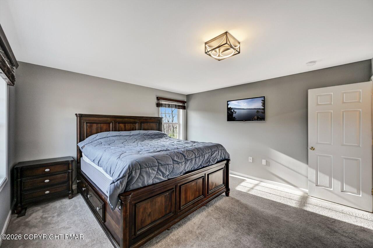 1013 Bear Swamp Road East Stroudsburg, PA 18302 - Photo 24 of 53 a bedroom with a bed and a chandelier