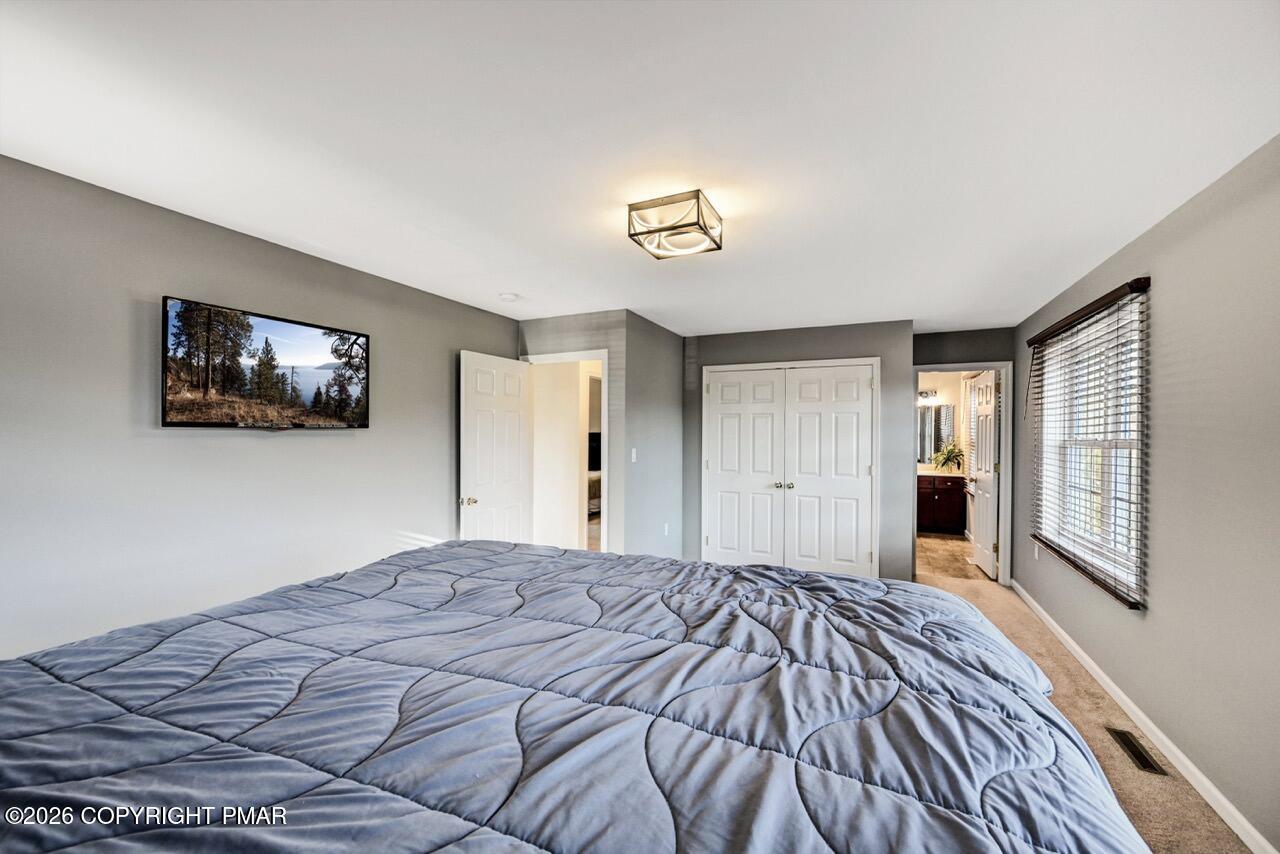 1013 Bear Swamp Road East Stroudsburg, PA 18302 - Photo 25 of 53 a bedroom with a large bed and a flat screen tv