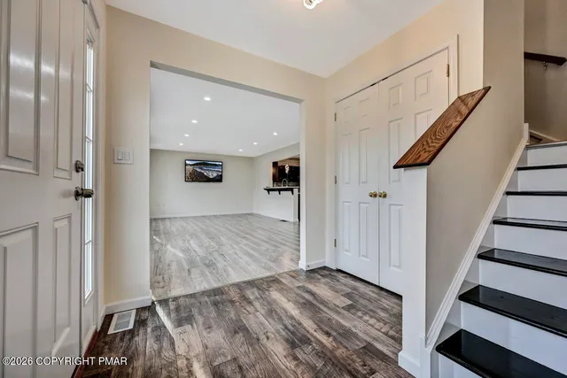 a view of a hallway with wooden floor and staircase