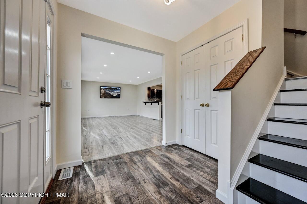 1013 Bear Swamp Road East Stroudsburg, PA 18302 - Photo 3 of 53 a view of a hallway with wooden floor and staircase