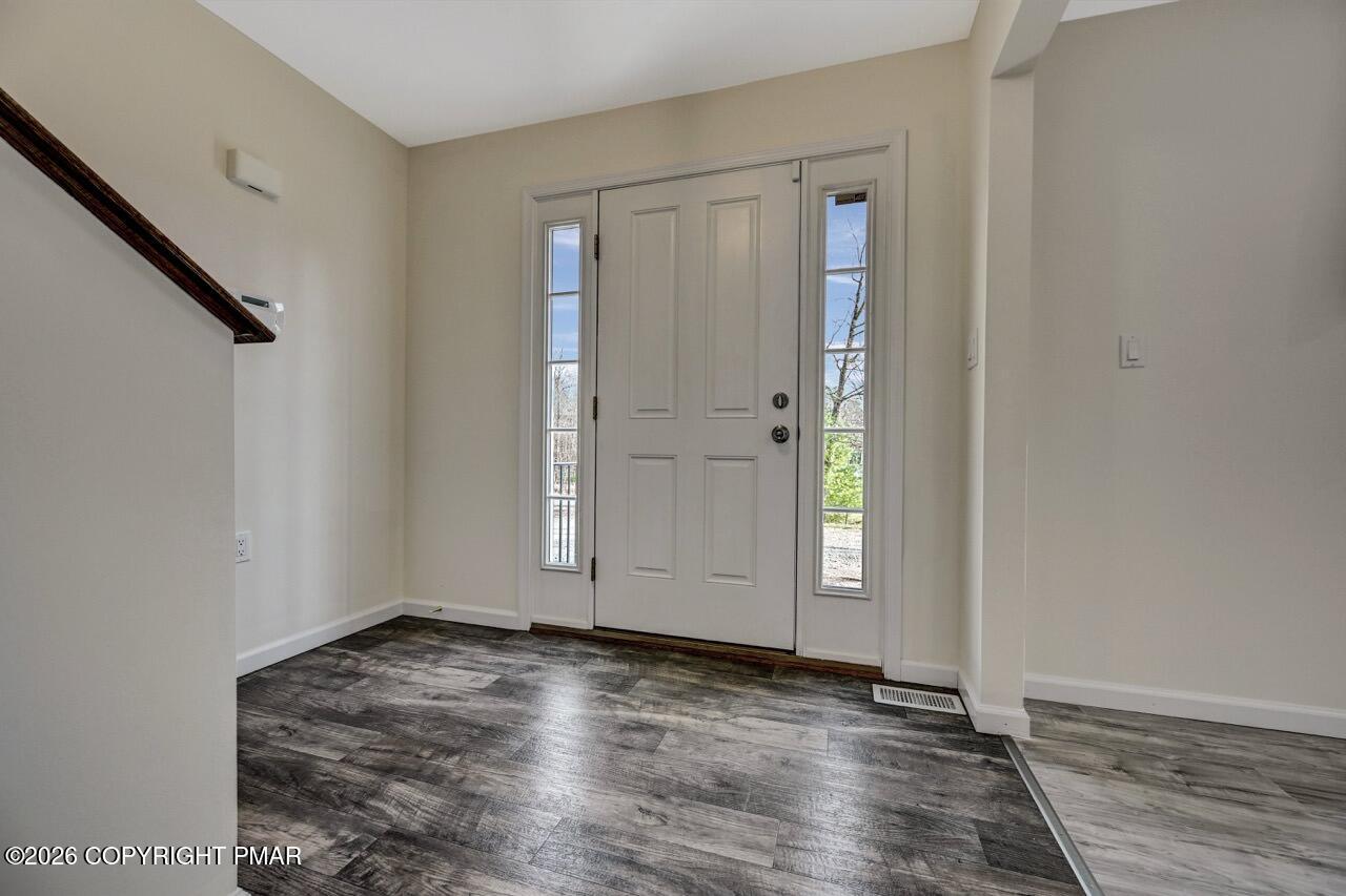 1013 Bear Swamp Road East Stroudsburg, PA 18302 - Photo 4 of 53 an empty room with wooden floor and windows
