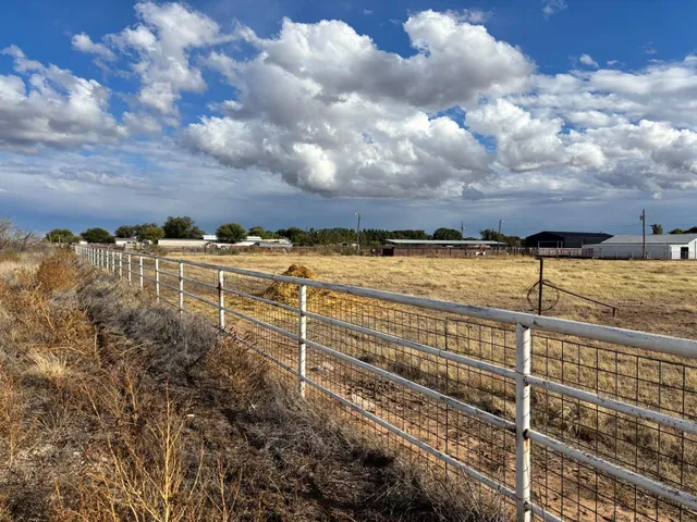 a view of a yard with wooden fence