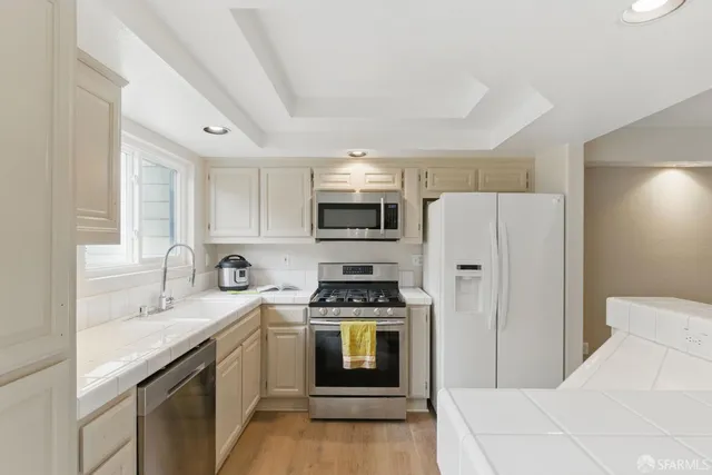 a kitchen with stainless steel appliances a refrigerator stove and sink