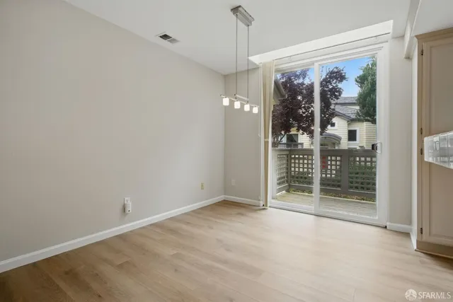 a view of a hallway with wooden floor and windows