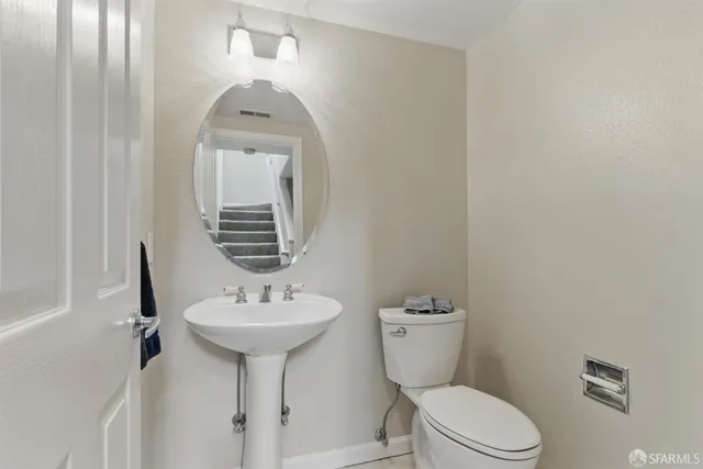 a bathroom with a toilet sink and mirror