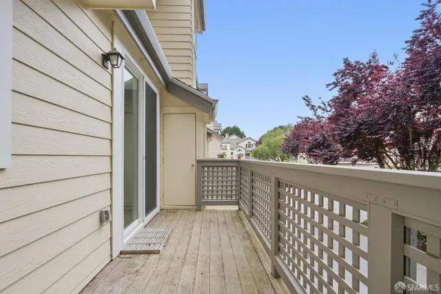 a view of a balcony with wooden floor and fence