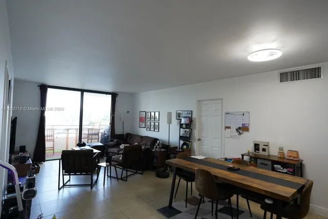 a living room with furniture a large window and a flat screen tv