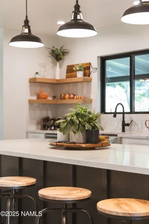 a kitchen with stainless steel appliances granite countertop a sink a stove a refrigerator and island with wooden floor