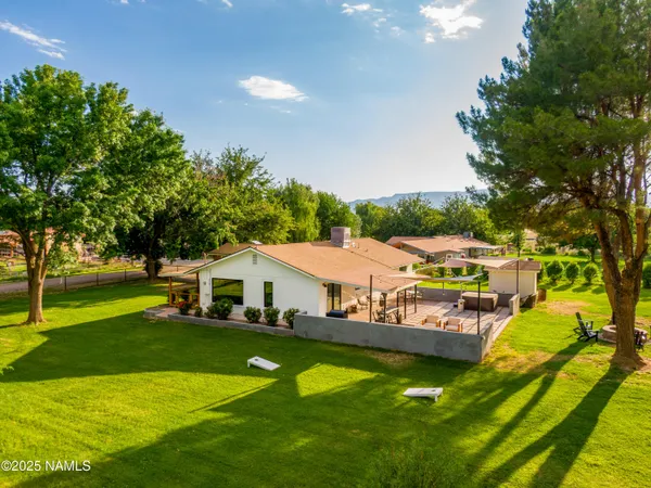 an aerial view of residential houses with outdoor space and trees