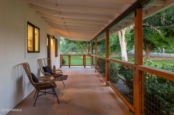 a balcony with couple of chairs and a couch