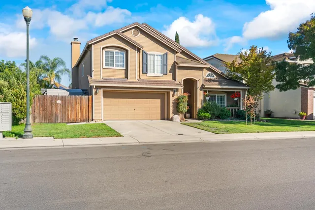 a front view of a house with a yard and garage