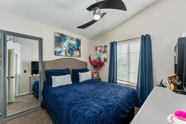 a bedroom with a bed a dresser and a window