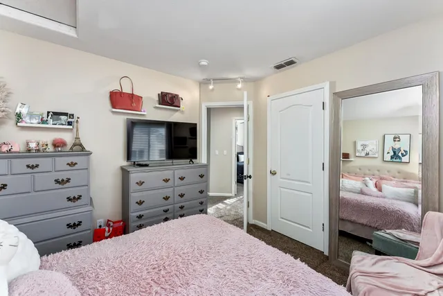 a bedroom with a bed and a painting on the wall