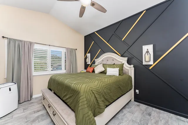 a large bedroom with a bed and flat screen tv