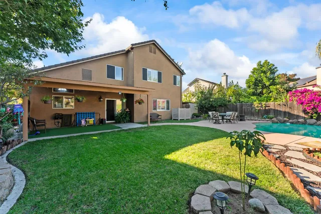 a view of a tables and chairs in patio next to a yard