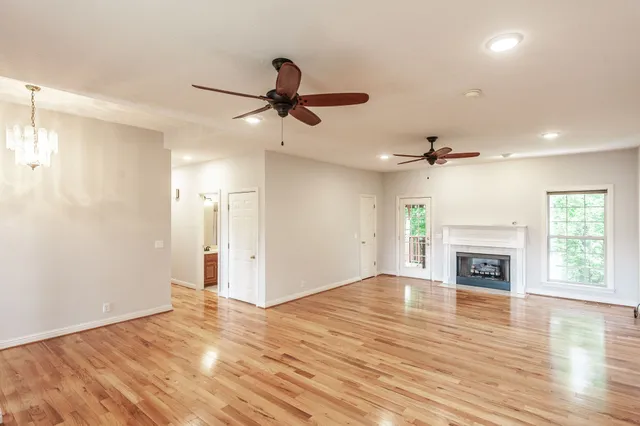 a view of an empty room with window and wooden floor