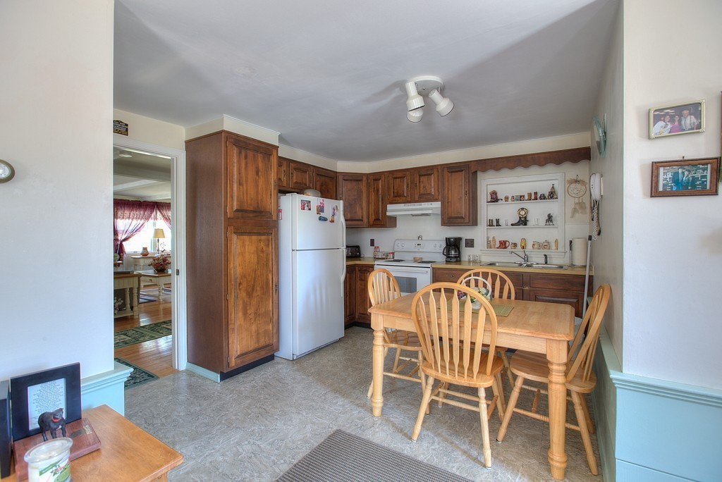 954 Chase Road Lunenburg, MA 01462 - Photo 21 of 27 a dining room with stainless steel appliances a dining table chairs and refrigerator
