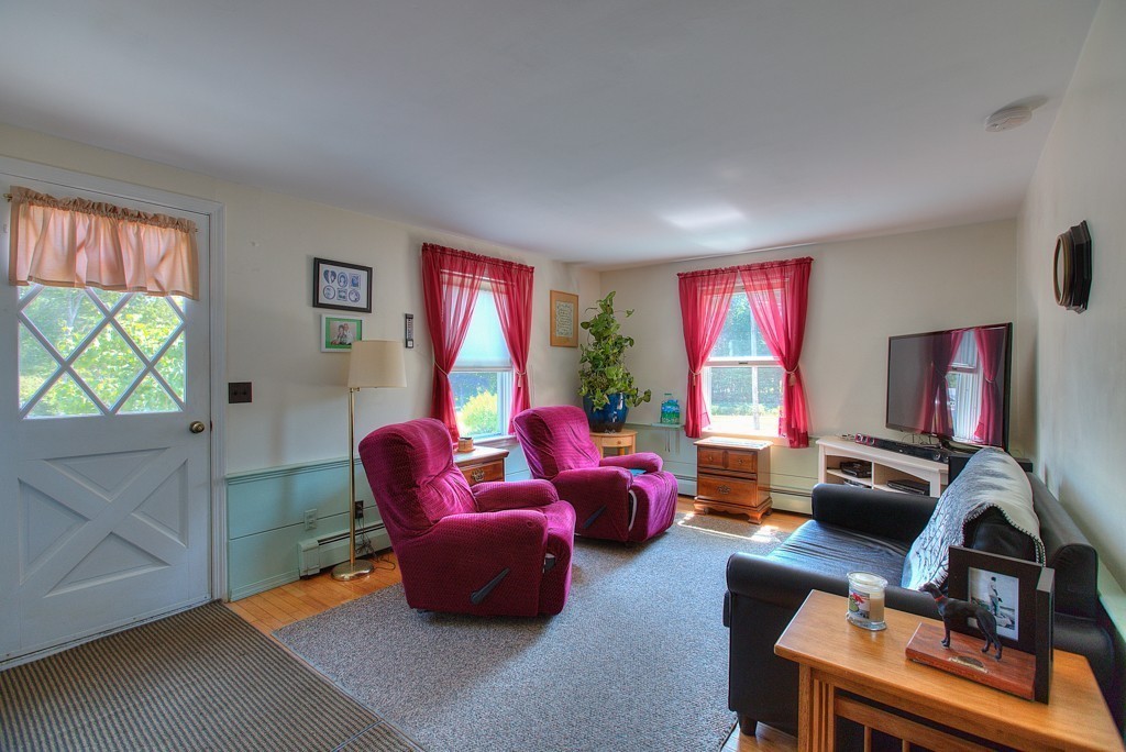 954 Chase Road Lunenburg, MA 01462 - Photo 22 of 27 a living room with furniture a flat screen tv and a large window