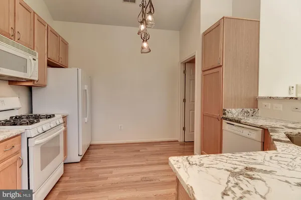 a kitchen with stainless steel appliances white cabinets and wooden floors
