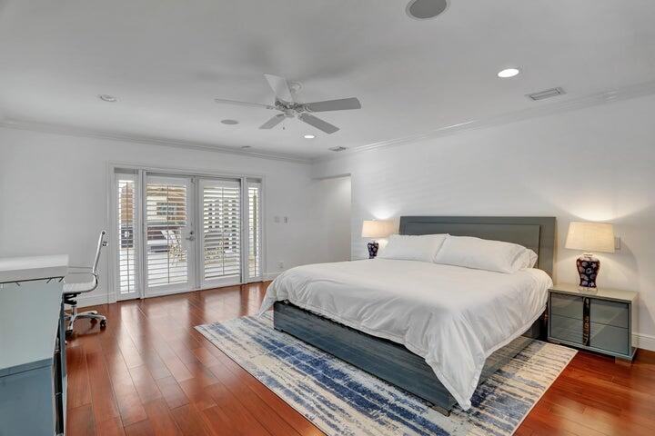 2100 Spanish River Road Boca Raton, FL 33432 - Photo 22 of 38 a spacious bedroom with a large bed and a chandelier