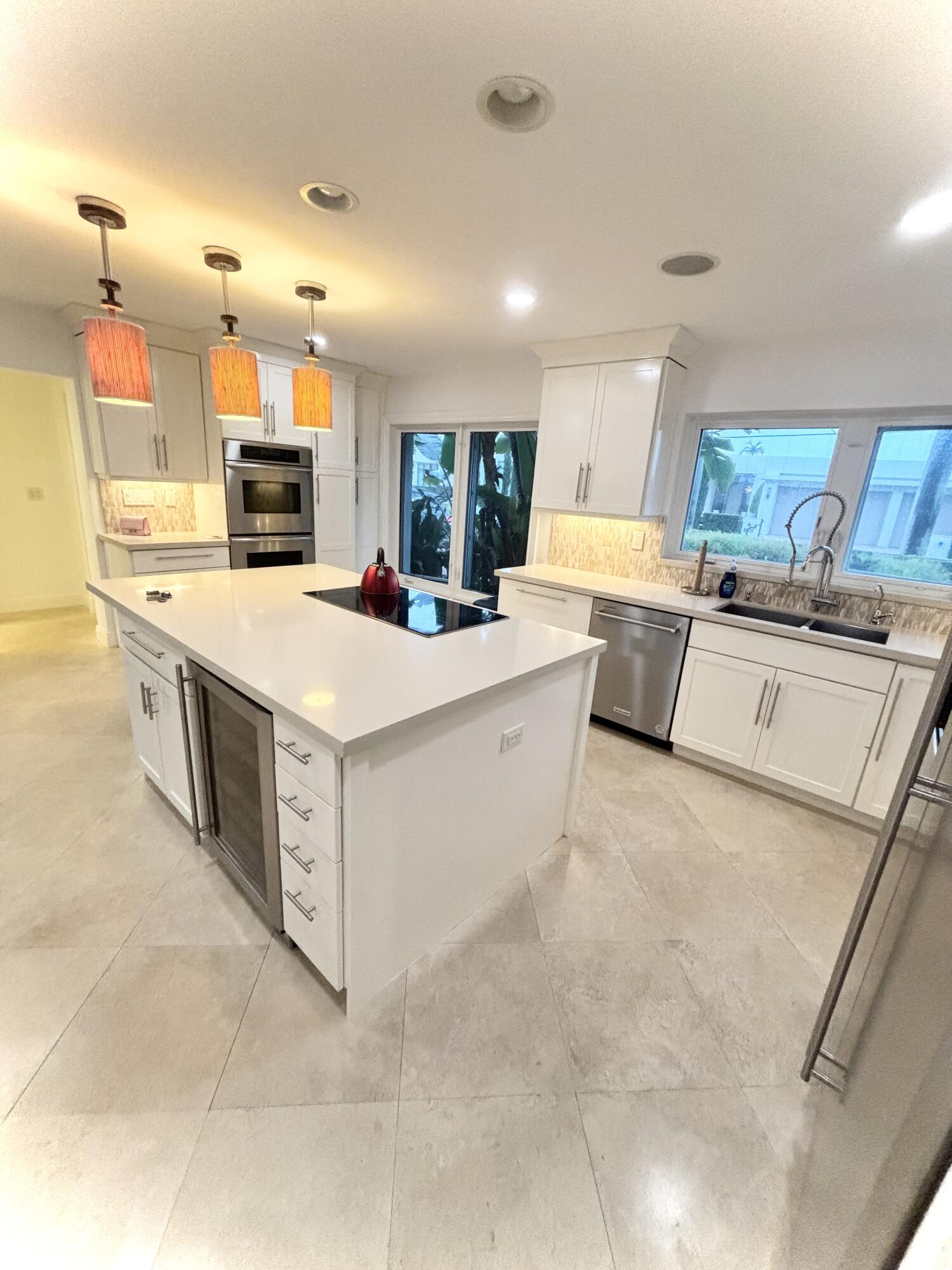 2100 Spanish River Road Boca Raton, FL 33432 - Photo 36 of 38 a large kitchen with a stove a sink dishwasher and a refrigerator with white cabinets