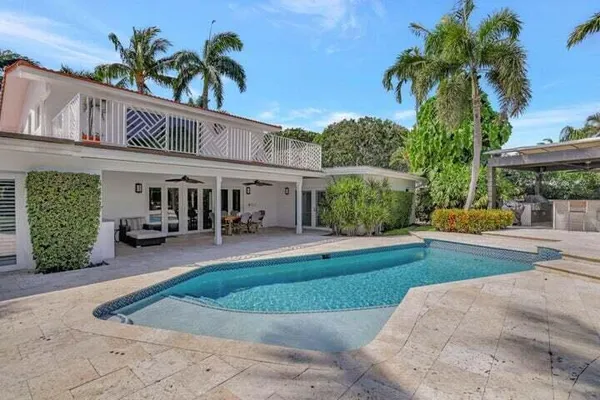 a view of a house with swimming pool and sitting area