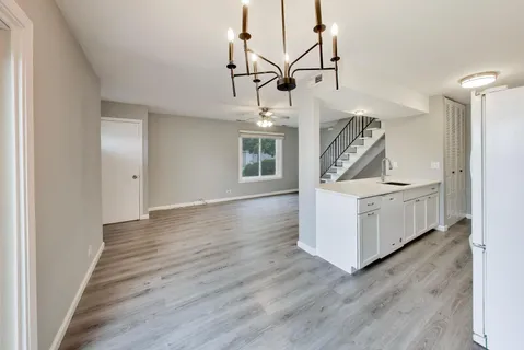 a view of a livingroom with wooden floor and a ceiling fan