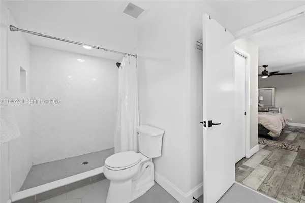 a bathroom with a granite countertop toilet a sink and shower
