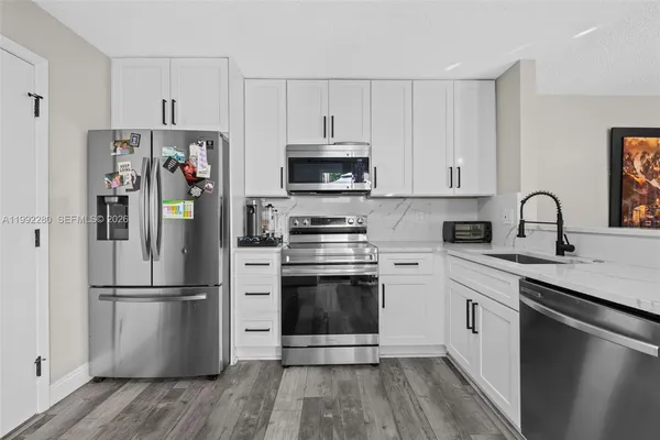 a kitchen with a refrigerator stove and white cabinets