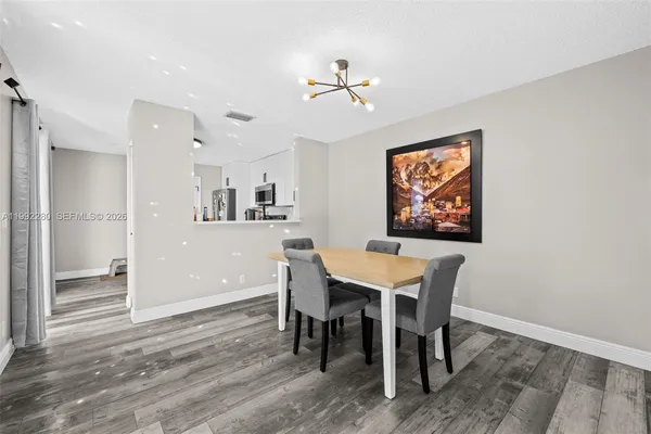a dining room with wooden floor and chandelier